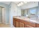 Bathroom featuring a double sink vanity with granite countertops and a framed mirror with lighting above at 17419 New Cross Cir, Lithia, FL 33547