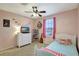 Bedroom features carpeted floors, ceiling fan and window with pink curtains, and a twin bed with throw pillows at 17419 New Cross Cir, Lithia, FL 33547