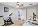 Bedroom featuring carpeted floors, ceiling fan and closet doors, and a desk workstation next to exercise equipment at 17419 New Cross Cir, Lithia, FL 33547