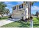 Two-story home features a two-car garage, a well-manicured lawn, and mature trees at 17419 New Cross Cir, Lithia, FL 33547