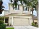 Two-story home with a two-car garage, brown shutters, and manicured landscaping at 17419 New Cross Cir, Lithia, FL 33547