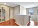Hallway features hardwood floors, white trim, and an open bookcase filled with an assortment of reading material at 17419 New Cross Cir, Lithia, FL 33547