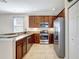 Modern kitchen featuring stainless steel appliances, dark wood cabinets, and granite countertops at 17419 New Cross Cir, Lithia, FL 33547