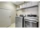 Laundry Room features tiled floors, wire shelving, and front loading washer and dryer at 17419 New Cross Cir, Lithia, FL 33547