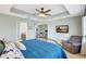 Spacious main bedroom with tray ceiling, ensuite bathroom, and a sitting area with TV at 17419 New Cross Cir, Lithia, FL 33547