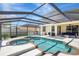 View of the enclosed pool and spa area with screen enclosure, and outdoor seating on the patio at 17419 New Cross Cir, Lithia, FL 33547