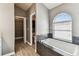 Spacious bathroom featuring bathtub with tile surround, large window and walk-in closet at 2719 Brookville Dr, Valrico, FL 33596