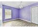 Bright bedroom with purple walls, wood-look flooring, and a decorative chandelier at 2719 Brookville Dr, Valrico, FL 33596