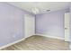 Cozy bedroom with wood-look tile flooring, lavender paint, and a decorative chandelier at 2719 Brookville Dr, Valrico, FL 33596