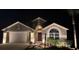 Charming single-Gathering home featuring manicured landscaping and a two-car garage, beautifully lit at night at 2719 Brookville Dr, Valrico, FL 33596