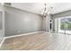 Spacious living room features wood-look tile flooring and sliding glass doors to the outdoor pool at 2719 Brookville Dr, Valrico, FL 33596