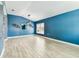 Bright living room with blue accent wall, wood-look tile flooring and stylish light fixture at 2719 Brookville Dr, Valrico, FL 33596