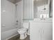 Well-lit bathroom featuring a white vanity, toilet, and a shower-tub combination with striped wallpaper at 309 Countryside Key Blvd, Oldsmar, FL 34677