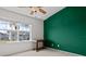 Bright bedroom featuring a large window, ceiling fan, and an accent wall at 309 Countryside Key Blvd, Oldsmar, FL 34677