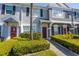 Charming townhome exterior with well-manicured bushes and a striking red front door at 309 Countryside Key Blvd, Oldsmar, FL 34677