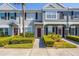 Well-manicured front yard with landscaping and walkway leading to the townhome entrance with a red door at 309 Countryside Key Blvd, Oldsmar, FL 34677