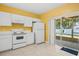 Bright kitchen featuring white appliances and cabinets, with a sliding glass door leading to a patio at 309 Countryside Key Blvd, Oldsmar, FL 34677