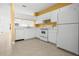 Well-lit kitchen featuring white cabinets and appliances, with an opening to the living area at 309 Countryside Key Blvd, Oldsmar, FL 34677