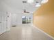 Bright living room boasts large windows, neutral tile flooring, and a ceiling fan at 309 Countryside Key Blvd, Oldsmar, FL 34677