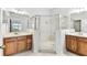 Bathroom featuring dual vanities, a glass-enclosed shower, and tile floors at 31434 Shaker Cir, Wesley Chapel, FL 33543