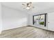Bedroom with wood-look floors, ceiling fan, and a window overlooking the backyard at 31434 Shaker Cir, Wesley Chapel, FL 33543