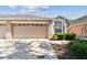 Exterior view of a home's two-car garage and landscaped front yard at 31434 Shaker Cir, Wesley Chapel, FL 33543