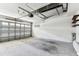 An empty two car garage with a garage door and a wall with shelves at 31434 Shaker Cir, Wesley Chapel, FL 33543