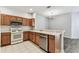 Well-lit kitchen featuring white appliances, ample cabinet space, and breakfast bar seating at 31434 Shaker Cir, Wesley Chapel, FL 33543