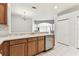 Open-concept kitchen with stainless steel dishwasher, and wood cabinets at 31434 Shaker Cir, Wesley Chapel, FL 33543