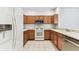 Clean kitchen with wood cabinetry, white appliances and light countertops at 31434 Shaker Cir, Wesley Chapel, FL 33543