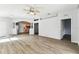 Bright living room featuring wood-look floors, an archway to the kitchen, and neutral paint at 31434 Shaker Cir, Wesley Chapel, FL 33543
