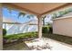 View of covered patio with lush green grass and a white privacy fence at 31434 Shaker Cir, Wesley Chapel, FL 33543