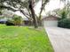 Charming single-story home featuring mature trees, green lawn, and an attached two-car garage at 3907 Applegate Cir, Brandon, FL 33511