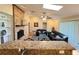 Open-concept living room with brick fireplace, wood floors, and seating area, viewed from kitchen bar at 3907 Applegate Cir, Brandon, FL 33511