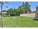 View of a large backyard with a green lawn, partial fence, and mature trees at 403 Cactus Cir, Seffner, FL 33584