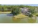 Aerial view of a home's backyard with a pool, screened-in porch, and a tranquil lake at 417 Ventura Dr, Oldsmar, FL 34677