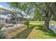 Backyard with a screened pool, patio, shed and a large tree overlooking a lake and white picket fence at 417 Ventura Dr, Oldsmar, FL 34677