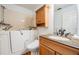 Well-lit bathroom featuring a walk-in tub, granite vanity, and wood-look cabinets at 417 Ventura Dr, Oldsmar, FL 34677