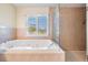 Bright bathroom featuring a large garden tub and separate glass-enclosed shower at 417 Ventura Dr, Oldsmar, FL 34677