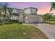 Elegant two-story home featuring a well-manicured lawn, palm trees and a two-car garage at 417 Ventura Dr, Oldsmar, FL 34677