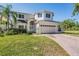 Charming two-story home with a brick driveway, lush lawn, and well-maintained landscaping at 417 Ventura Dr, Oldsmar, FL 34677