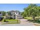 Charming two-story home with a brick driveway, lush lawn, and a pond view at 417 Ventura Dr, Oldsmar, FL 34677