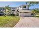 Charming two-story home featuring a brick driveway and a well-manicured lawn at 417 Ventura Dr, Oldsmar, FL 34677