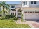 Charming front exterior with lush landscaping, brick driveway and a two-car garage at 417 Ventura Dr, Oldsmar, FL 34677