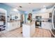 Open-concept kitchen boasts stainless steel appliances, white cabinets, and easy access to living area at 417 Ventura Dr, Oldsmar, FL 34677