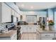 Well-lit kitchen with white cabinets, stainless steel appliances, and tile backsplash is move-in ready at 417 Ventura Dr, Oldsmar, FL 34677