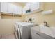 Laundry room with a washing machine, dryer, cabinets, and a utility sink at 417 Ventura Dr, Oldsmar, FL 34677