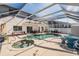 Backyard pool and hot tub area with a screen enclosure, patio furniture and views of the home at 417 Ventura Dr, Oldsmar, FL 34677