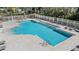 Community pool featuring a crisp blue pool, ample lounge chairs, and a surrounding fence for added privacy and security at 417 Ventura Dr, Oldsmar, FL 34677