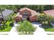 Aerial view of a residence featuring a tile roof, two-car garages, and a tree-lined front yard at 4289 Ortona Ln, Wesley Chapel, FL 33543